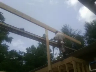 Carpenter setting a ridge beam over a new addition frame — Ice Dam Removal by Roofing Brothers in Parkers Prairie