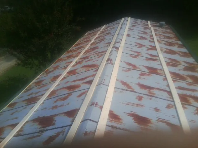 Rusted metal roof panels with new wood purlins before replacement — Storm Damage Roof Repair in Parkers Prairie by Roofing Brothers