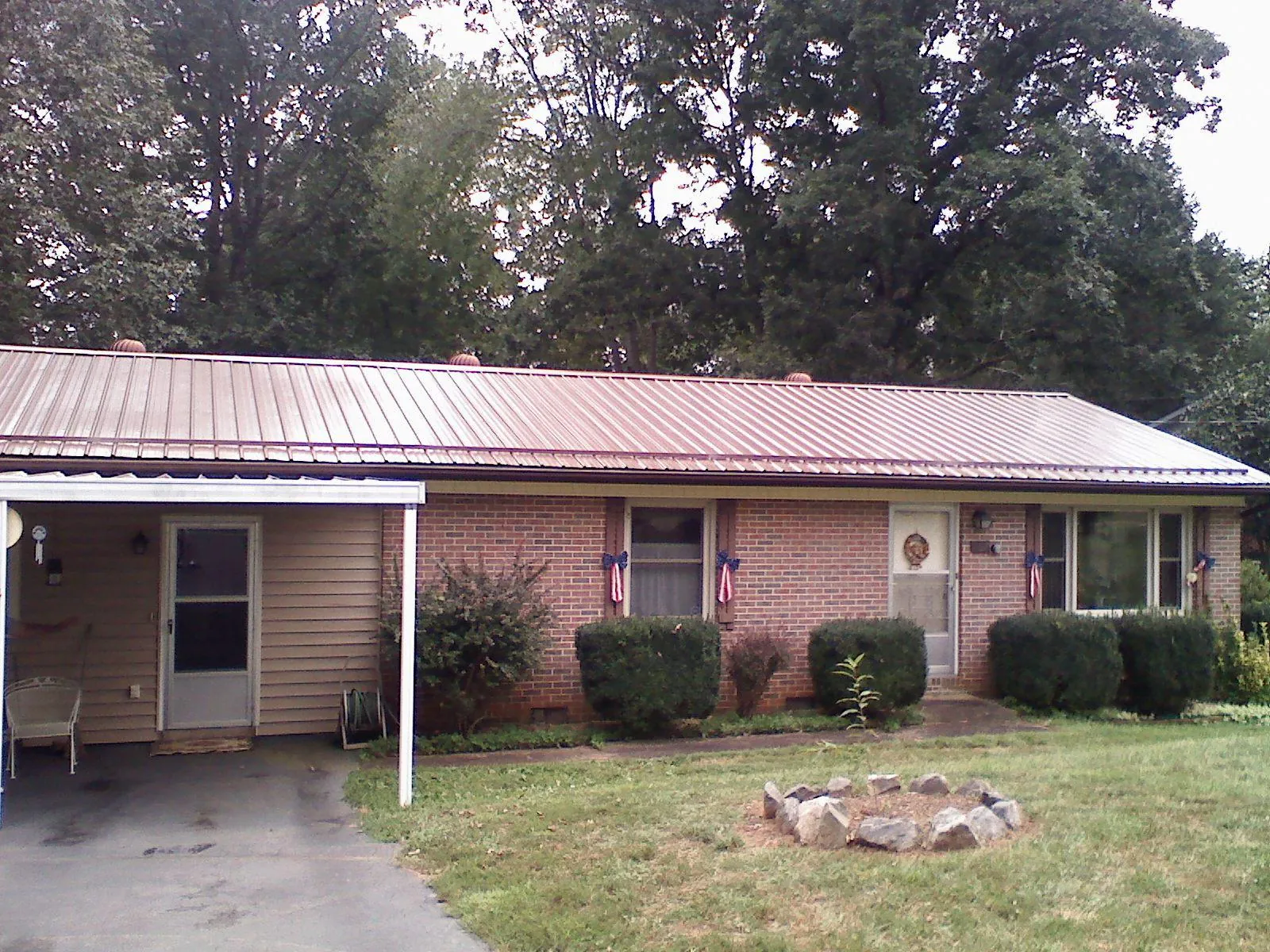 Bronze metal roof and carport on a brick ranch home — Roof Repair work by our crew in Parkers Prairie